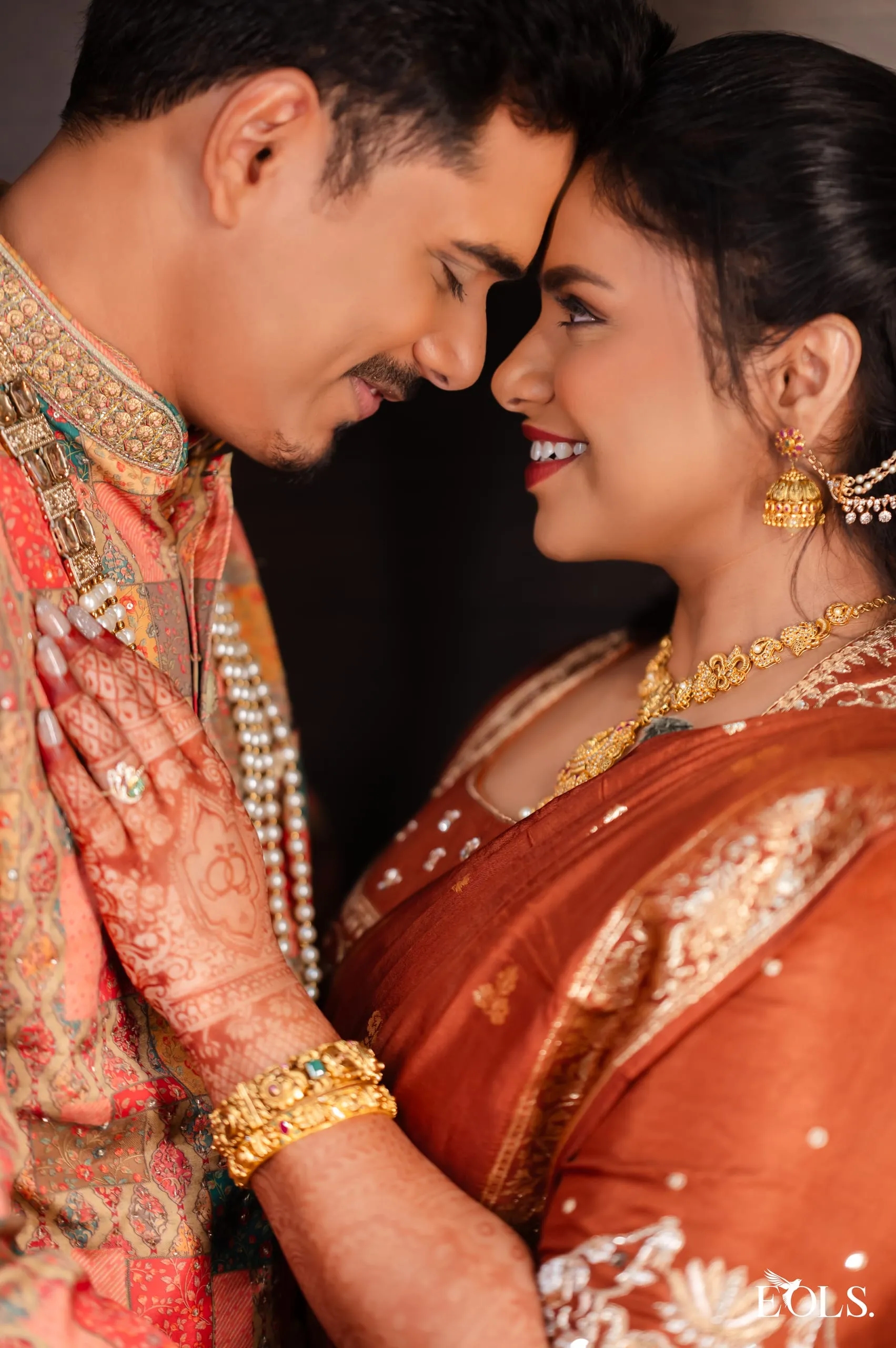 A couple touch foreheads, smiling at each other.