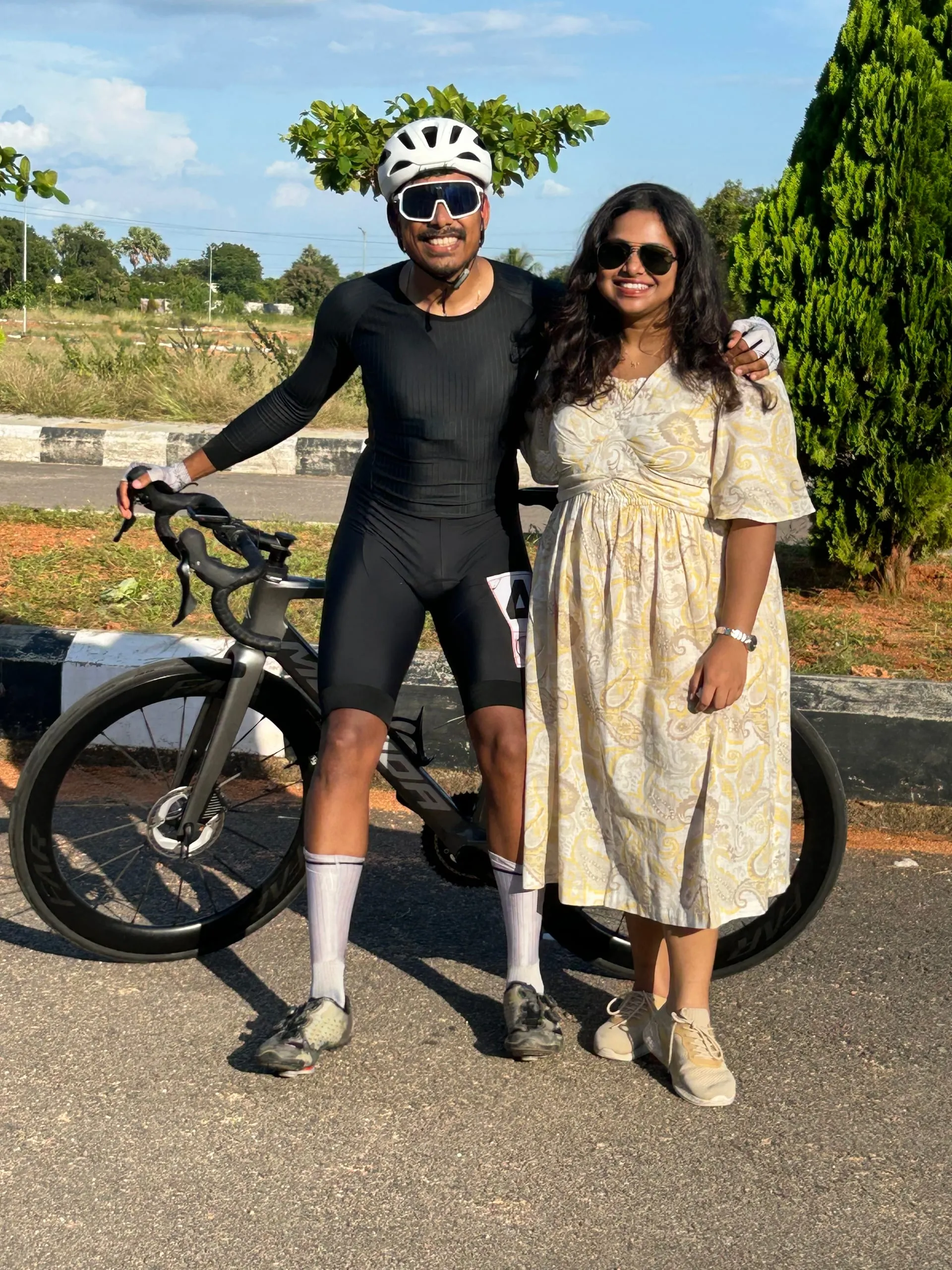 Gautham in cycling kit beside his bike, Swathi next to him