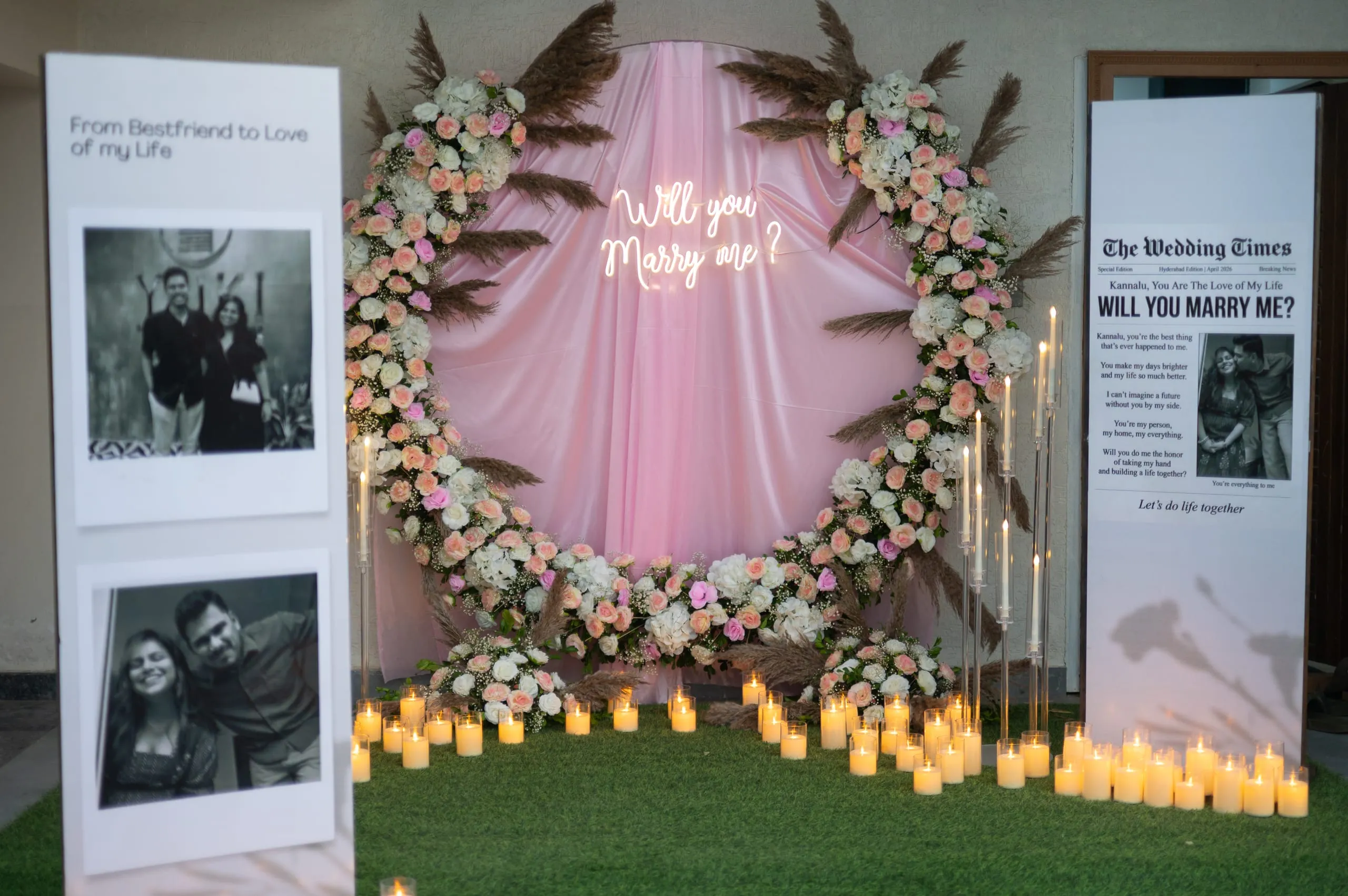 A floral "Will you marry me" backdrop with candles