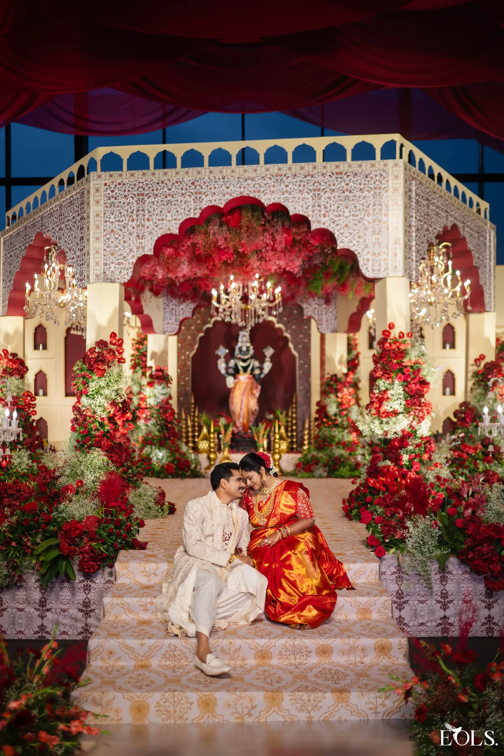 Swathi and Gautham seated together on the grand reception stage