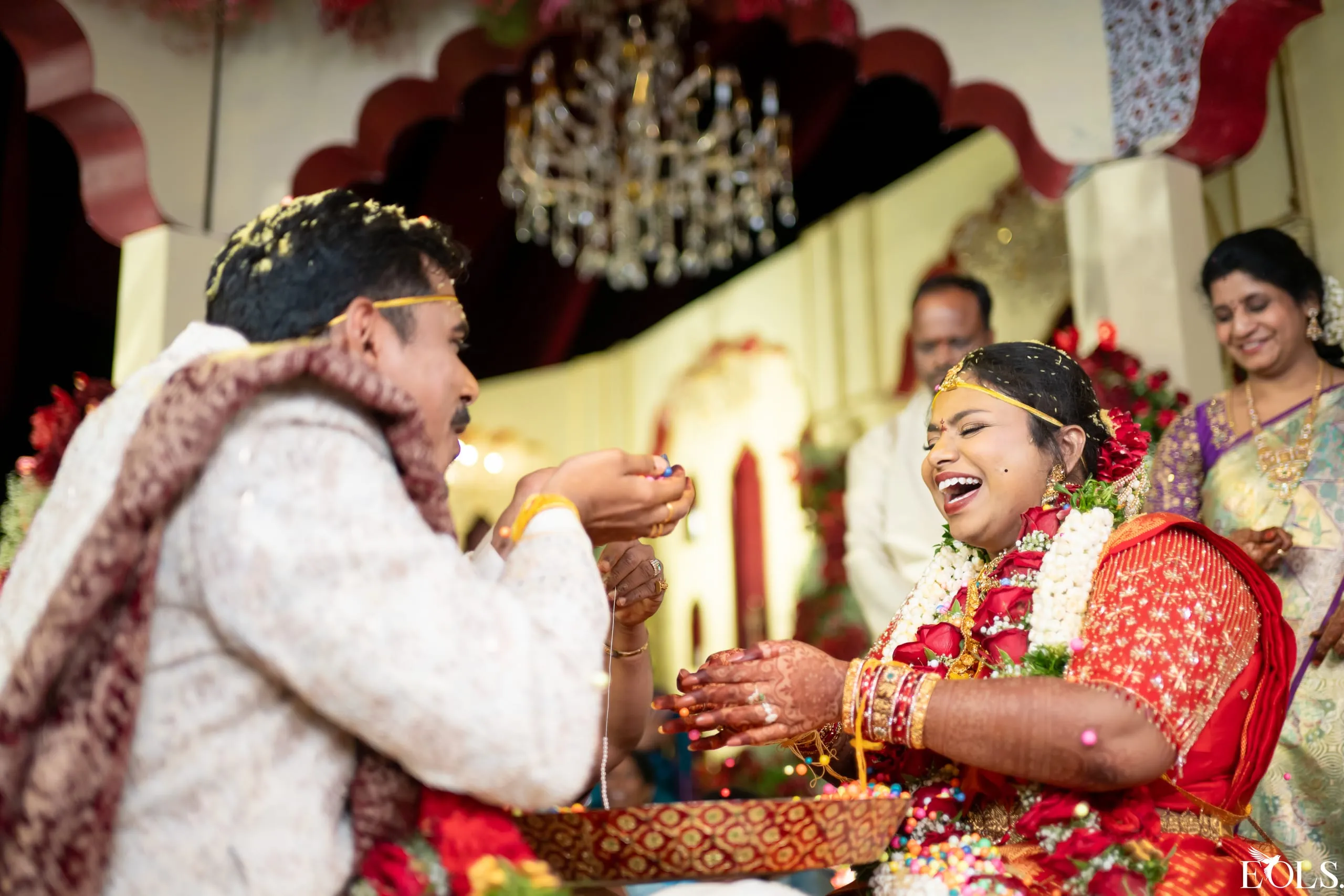 A couple laugh together during a ritual on stage.